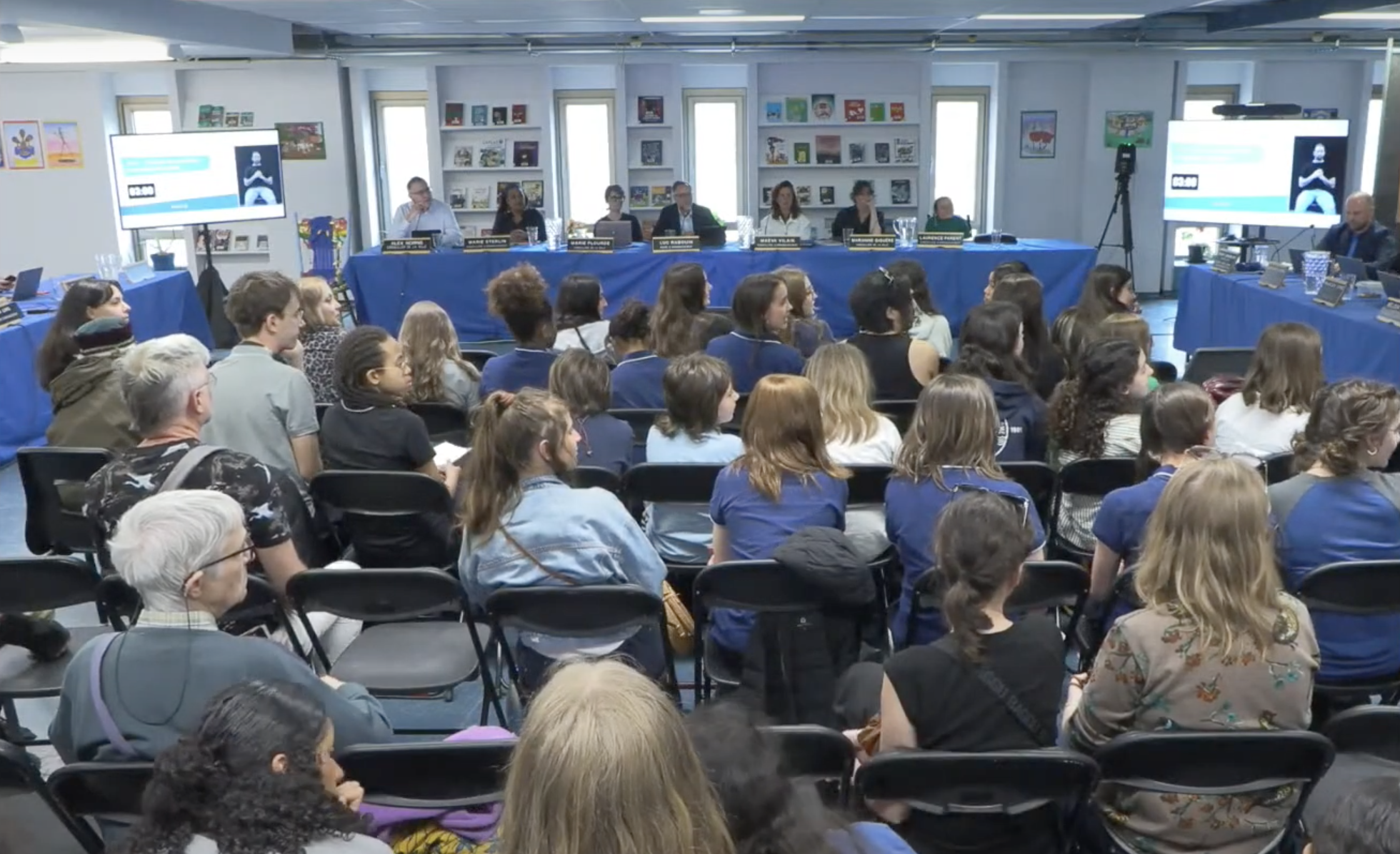 Cette photo tirée de la captation en direct de la séance montre à l'avant-plan de nombreux jeunes assis sur des chaises.