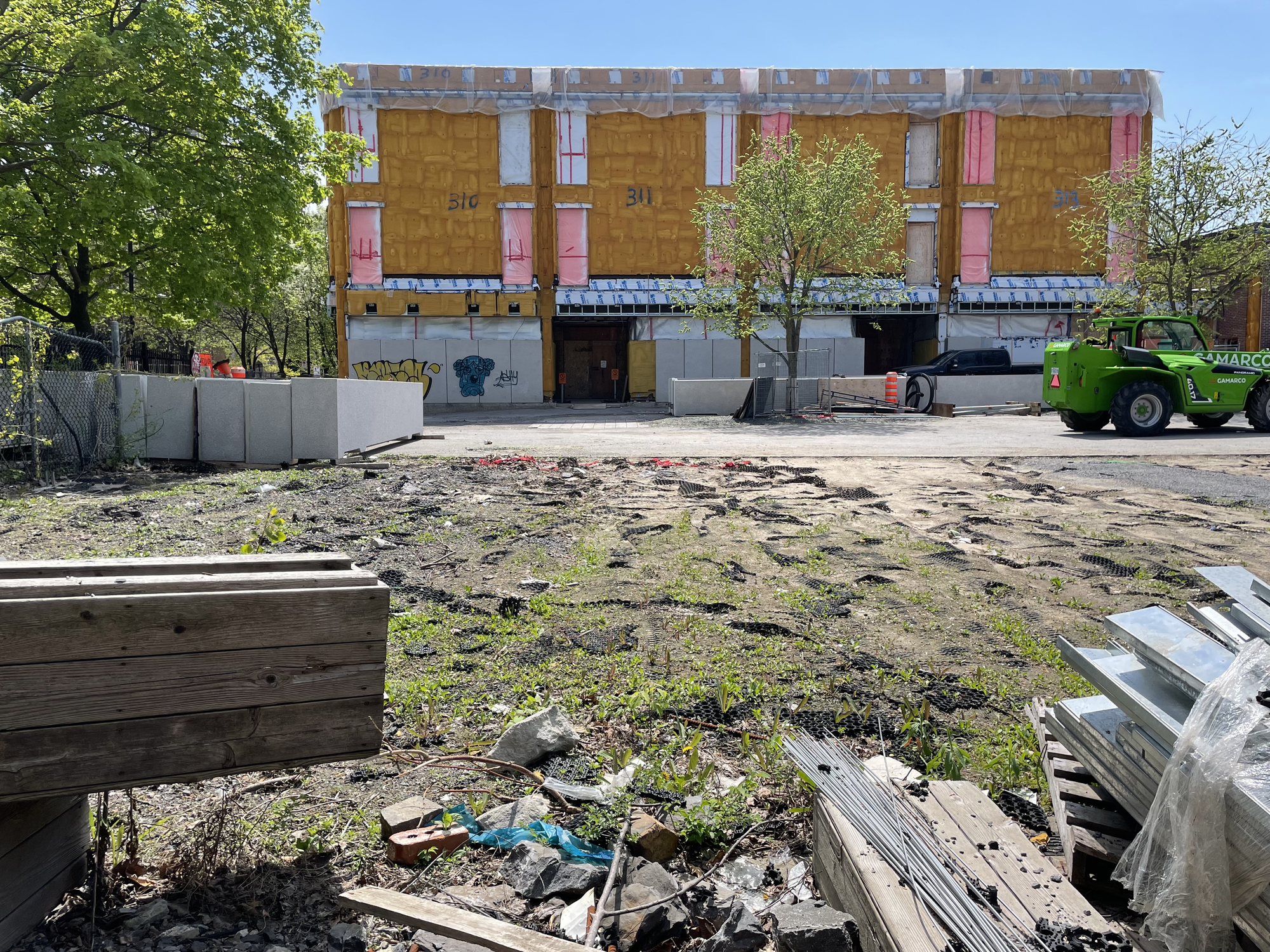 La photo montre la cour de l'école où se trouve des matériaux de construction et un camion