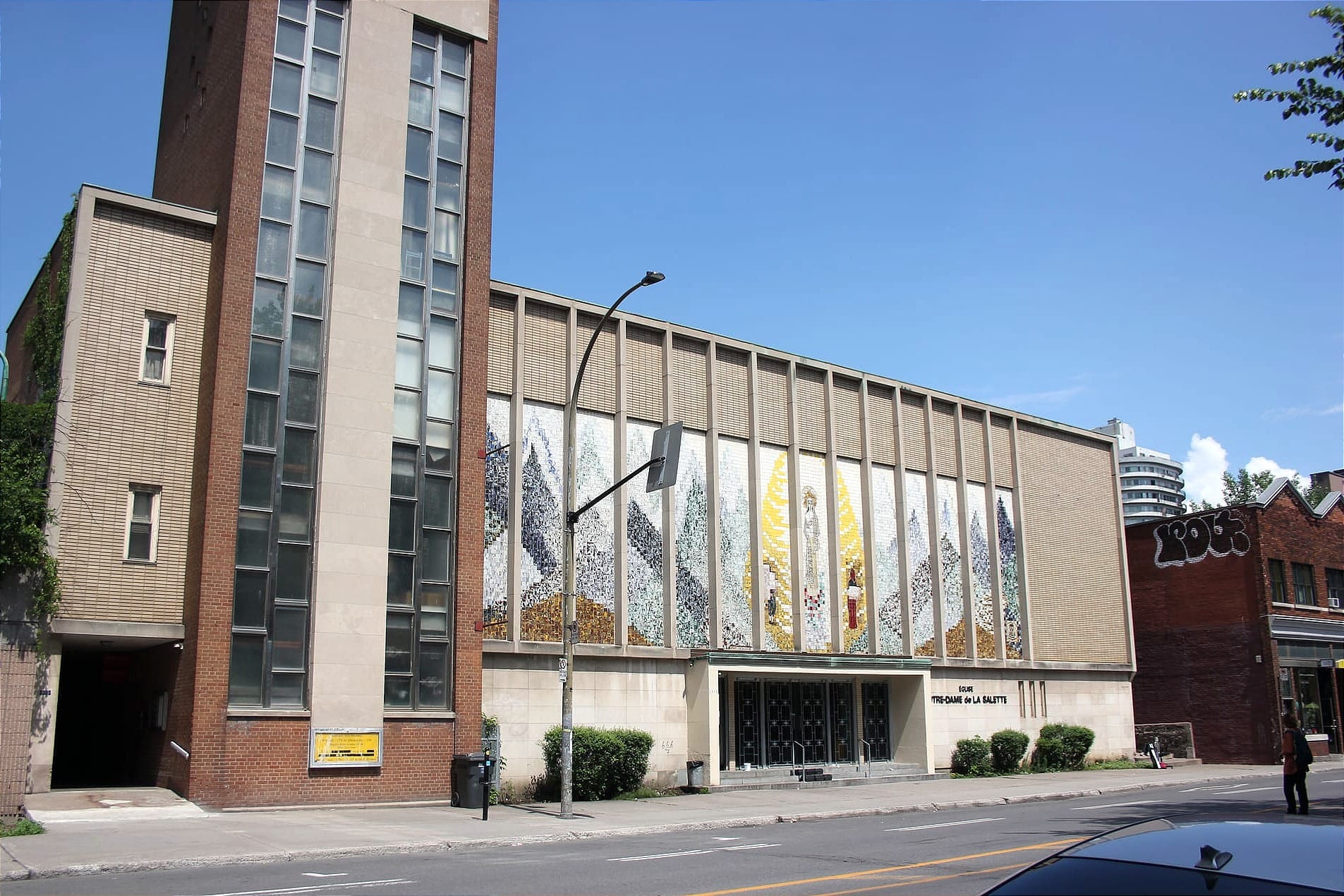 Photo de l'église sous un ciel bleu, prise du côté opposé de l'avenue du Parc. 