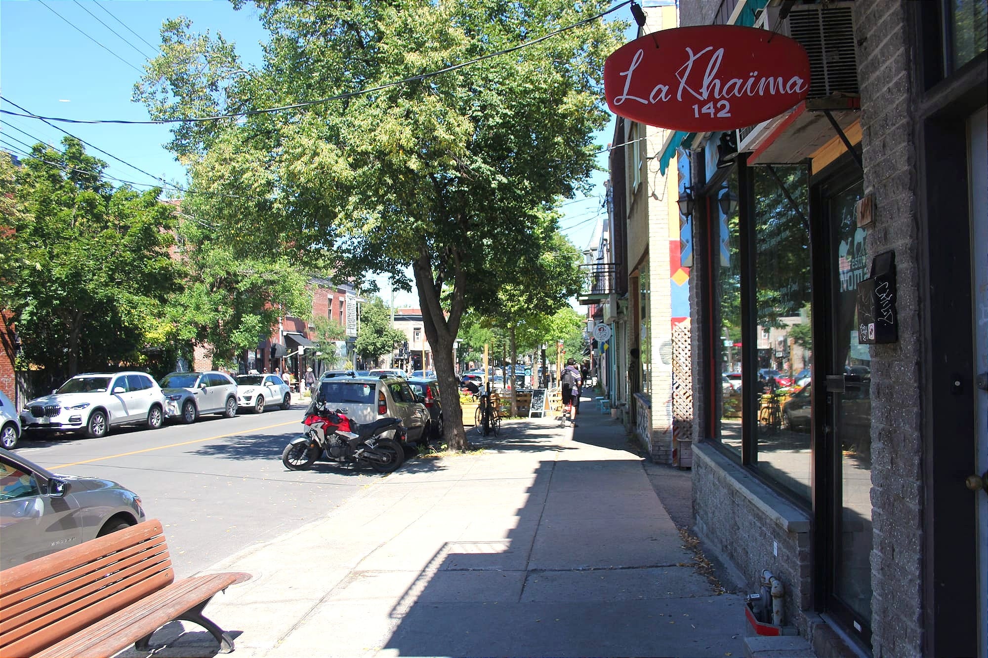 L'enseigne du restaurant trône au-dessus du trottoir de la rue Fairmount, ensoleillé. 