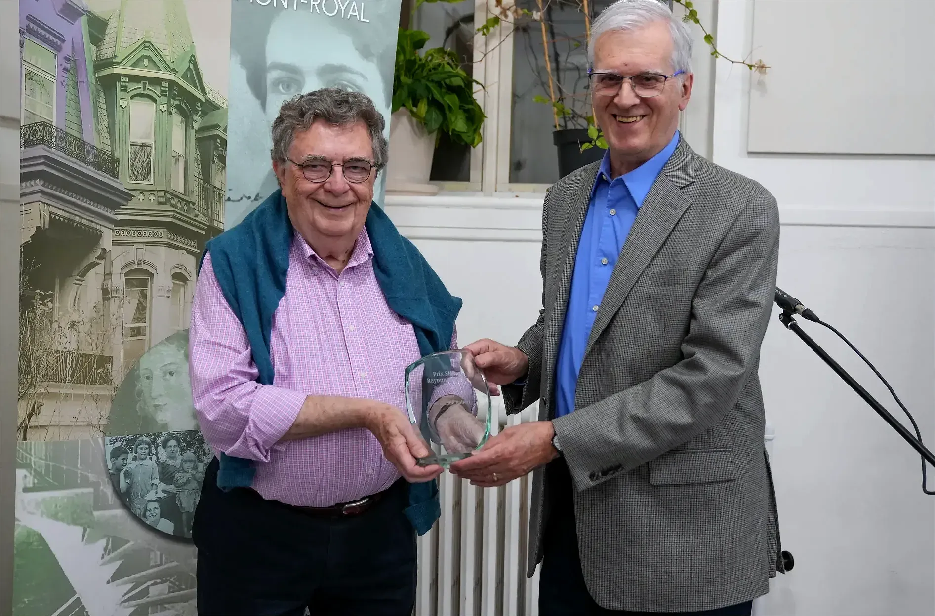 Les deux hommes souriants tiennent le trophée ensemble.