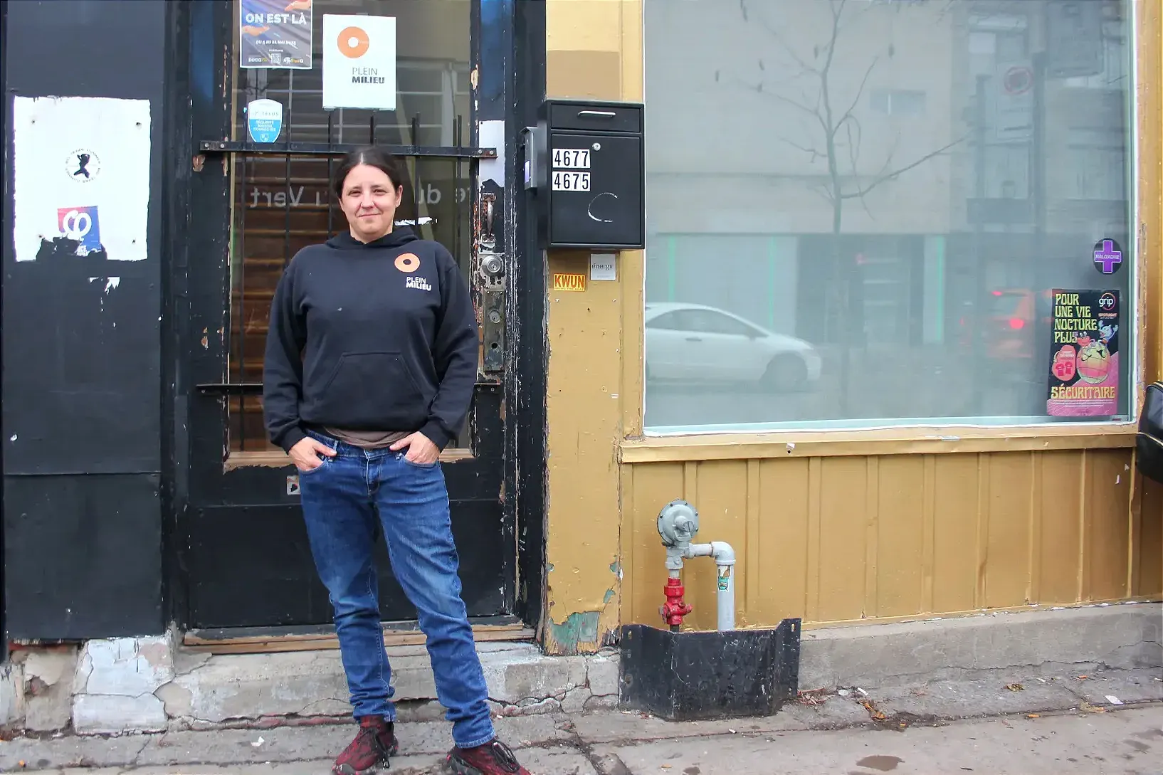Mme Lalumière se tient debout, devant les locaux de Plein Milieu. 