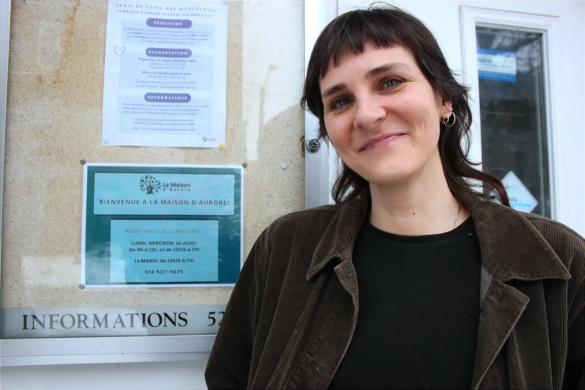 Mme Leclerc pose devant la porte d'entrée de la Maison d'Aurore.