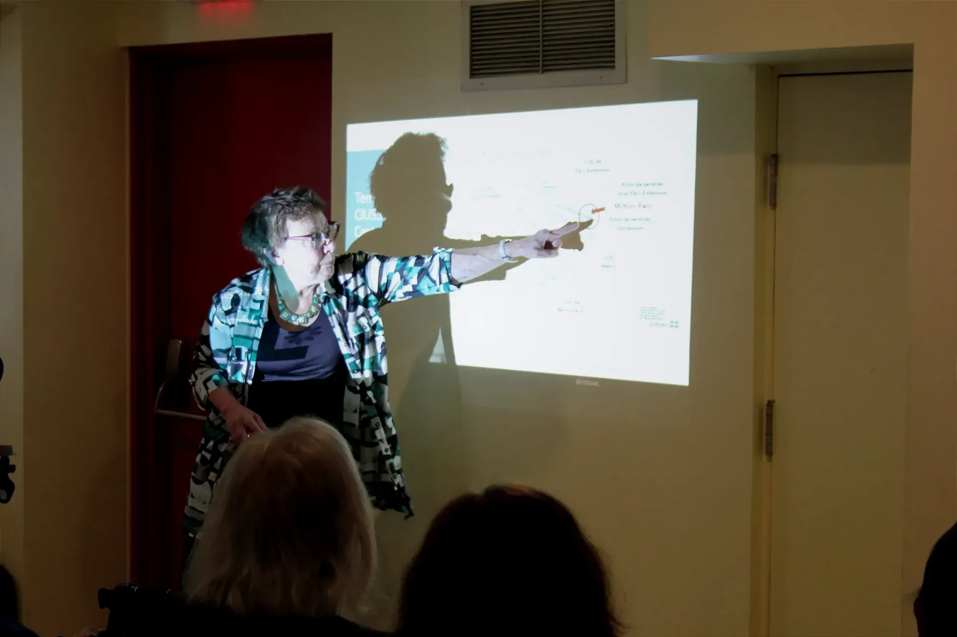 Mme Demczuk pointe des éléments projetés sur un mur.
