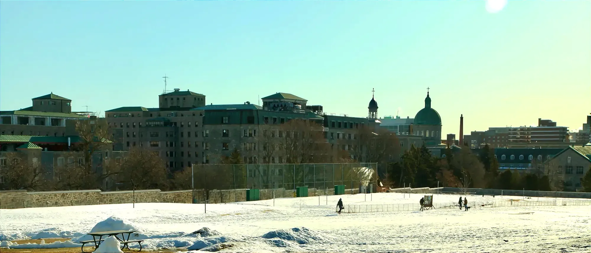 La Cité-des-Hospitalières vue de loin, derrière un parc Jeanne-Mance enneigé.