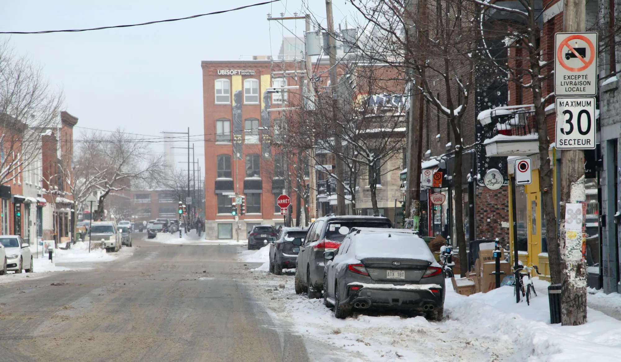La rue Saint-Viateur sous la neige, avec, en arrière-plan, un immeuble abritant des employés d'Ubisoft Montréal.