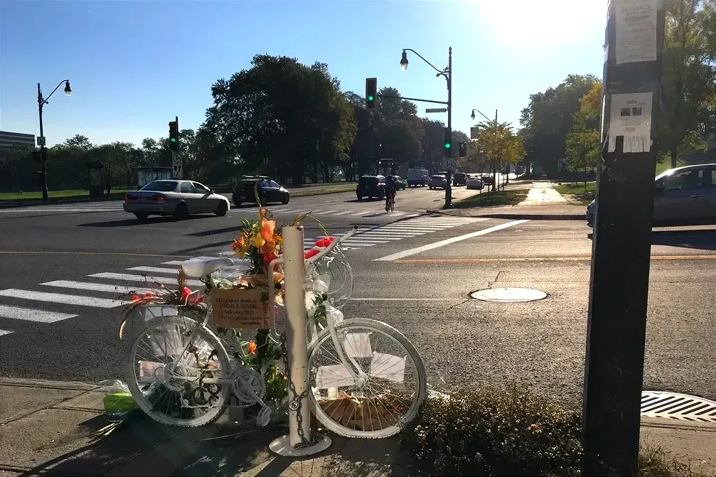 Un vélo blanc orné de fleurs est cadenassé sur le coin de l'avenue du Mont-Royal et de l'avenue du Parc.