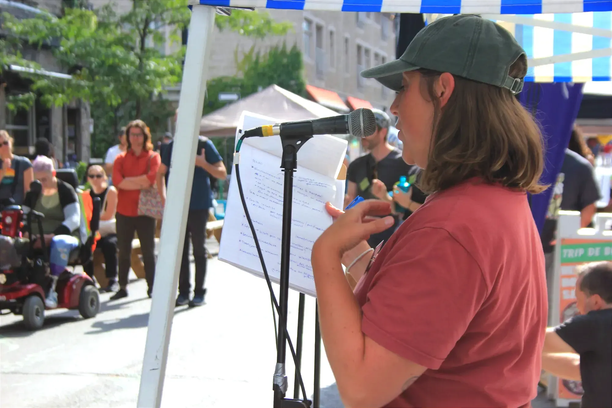 Mme Hélie-Martel tient un bloc-note. On voit quelques personnes à l'écoute en arrière-plan.
