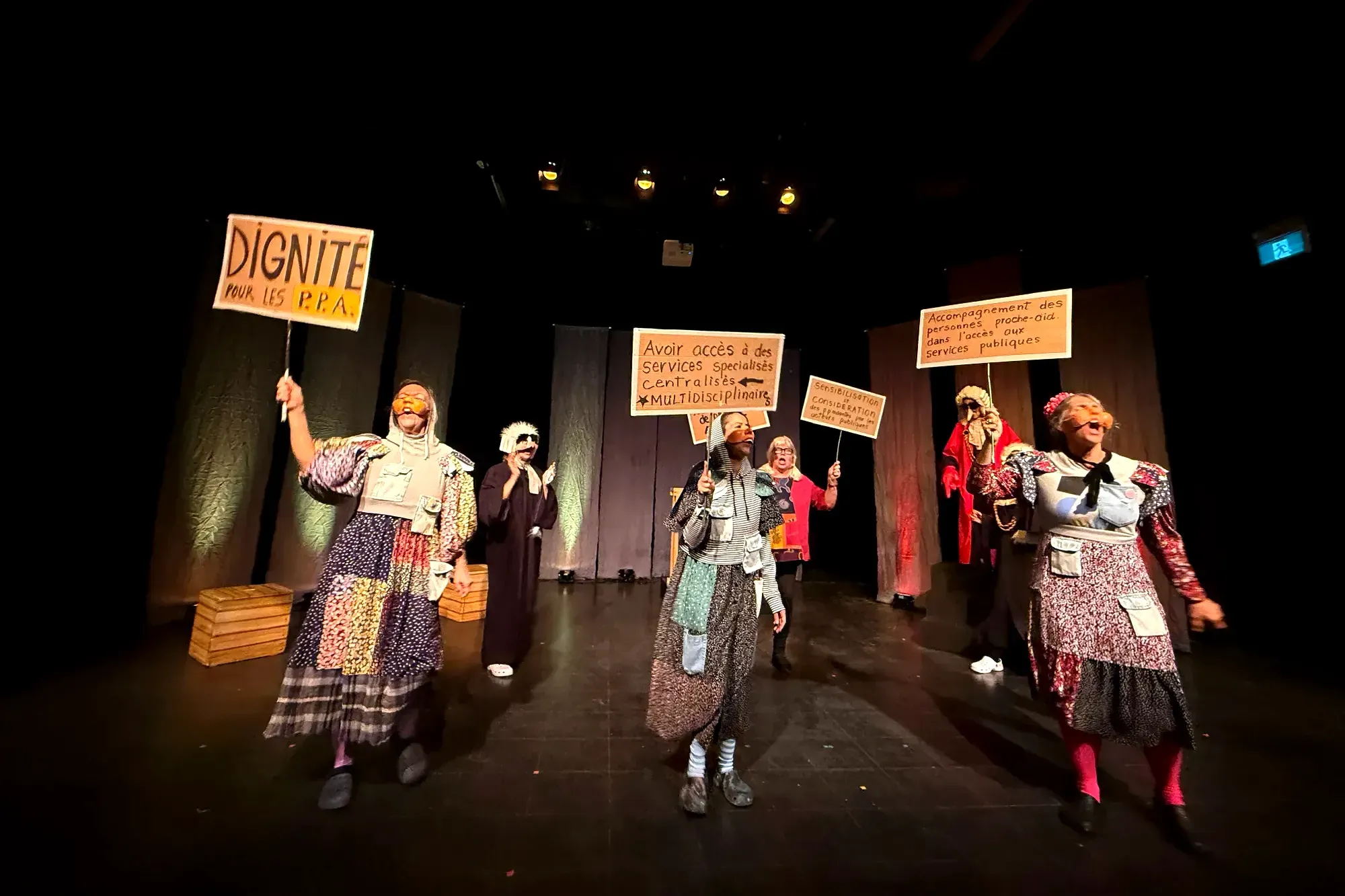 Les personnages portant masques et costumes mettent en scène une manifestations liée à la proche aidance.