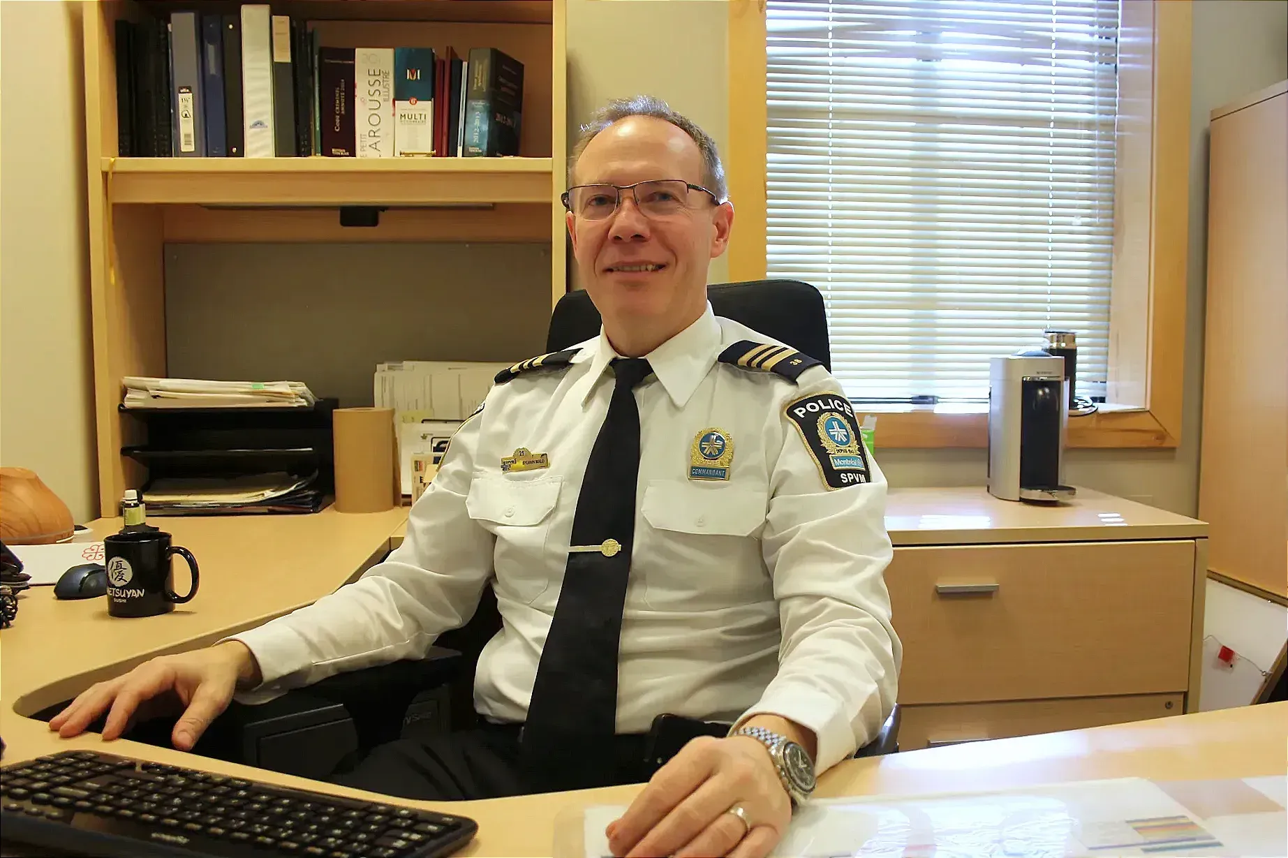 Sylvain Malo pose derrière son bureau, au PDQ38.