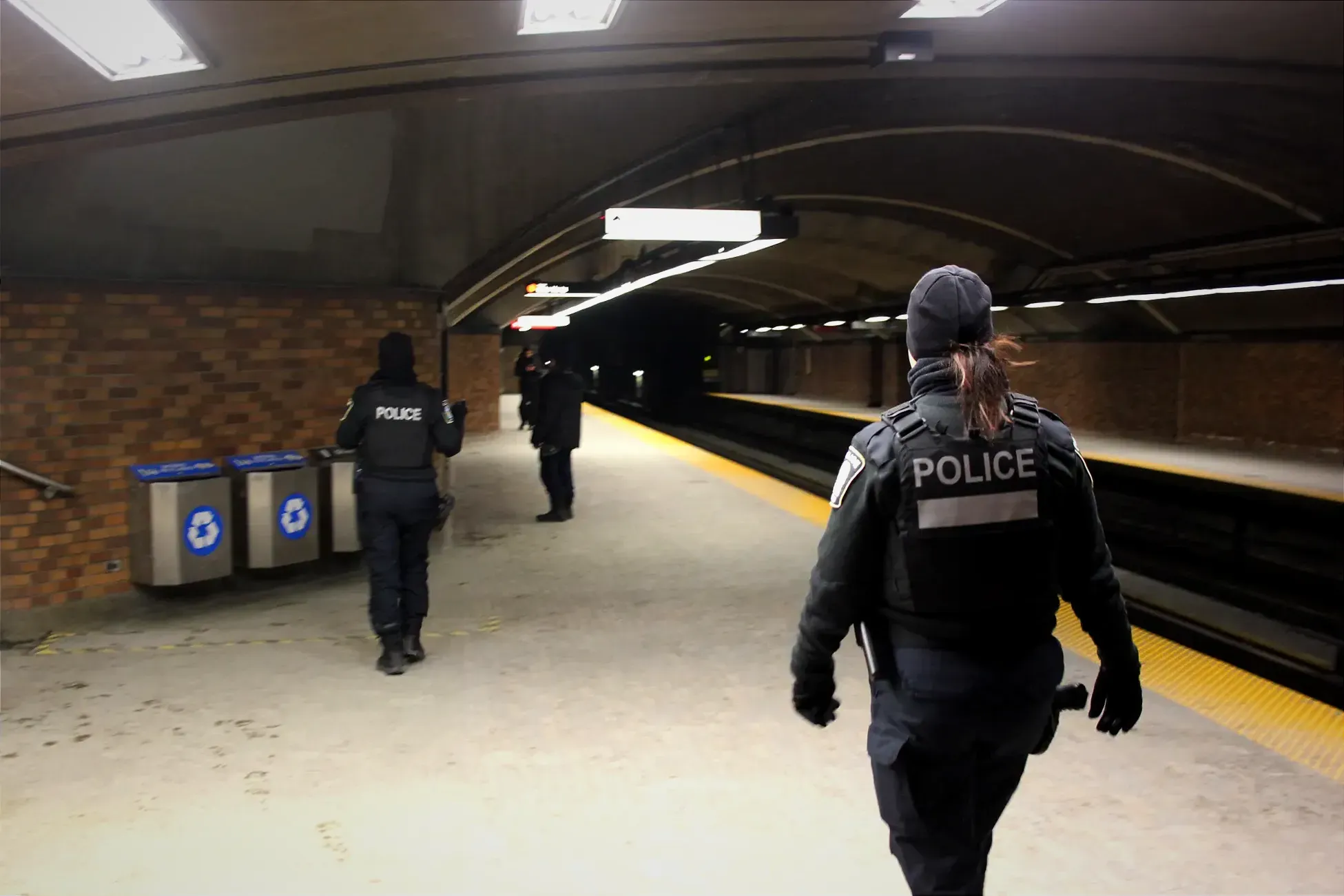 Les deux policières marchent de dos, à proximité des escaliers.