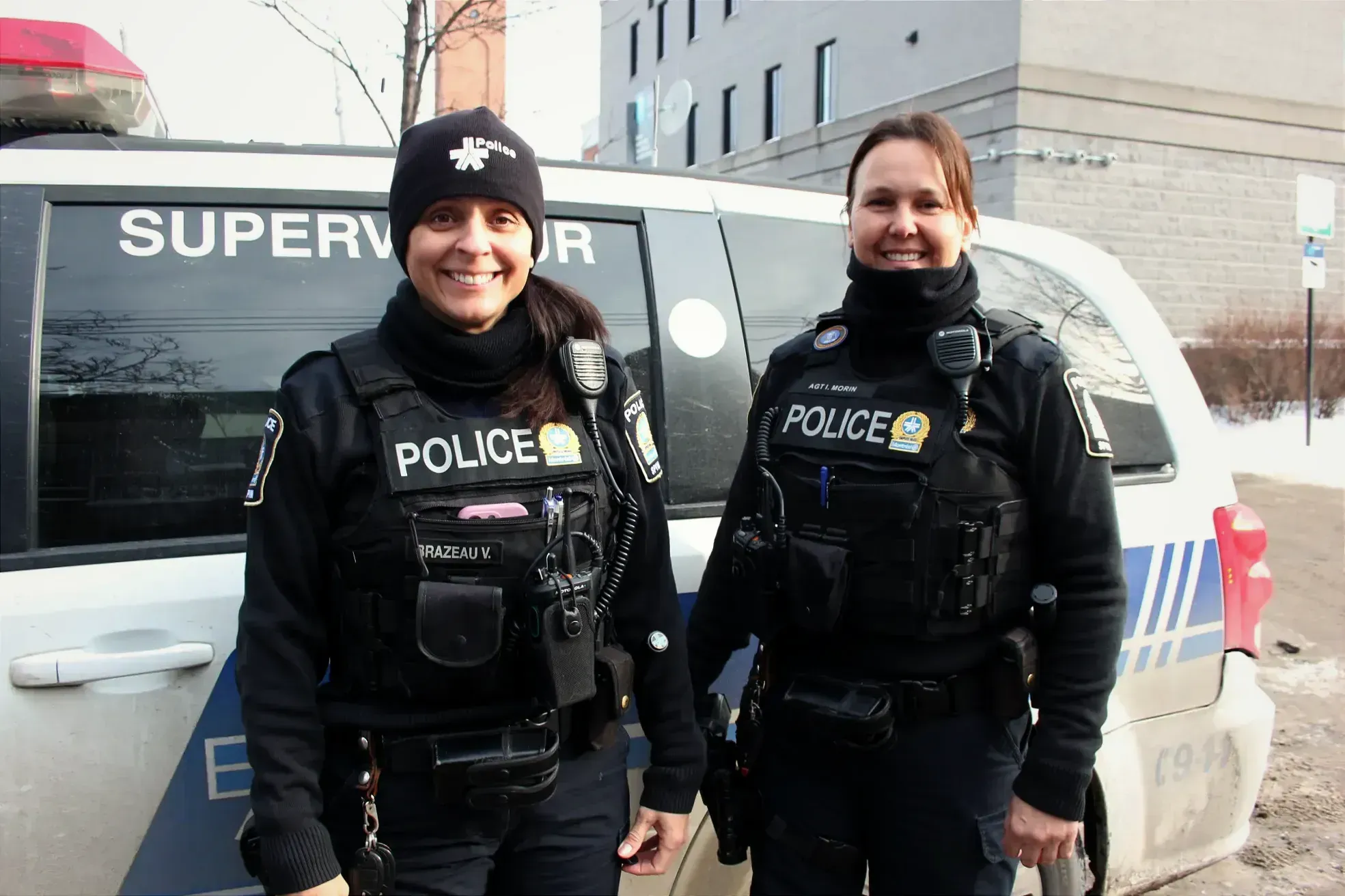 Le duo pose devant leur véhicule, stationné à proximité du poste de quartier 38.