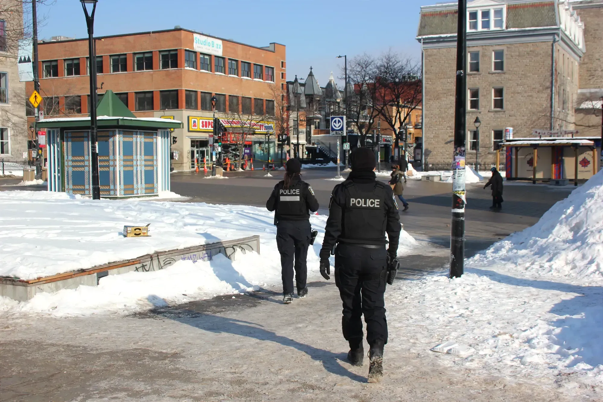 On voit les agentes de dos, avec l'intersection Berri–Mont-Royal devant elles.