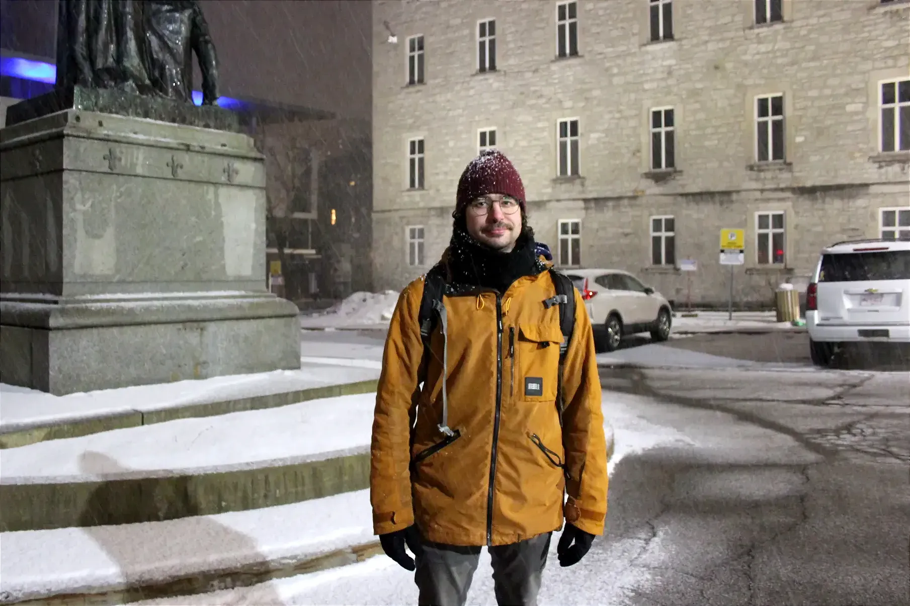 M. Lafrenière pose dans le stationnement de l'Hôtel-Dieu, à proximité du monument de Jeanne Mance.