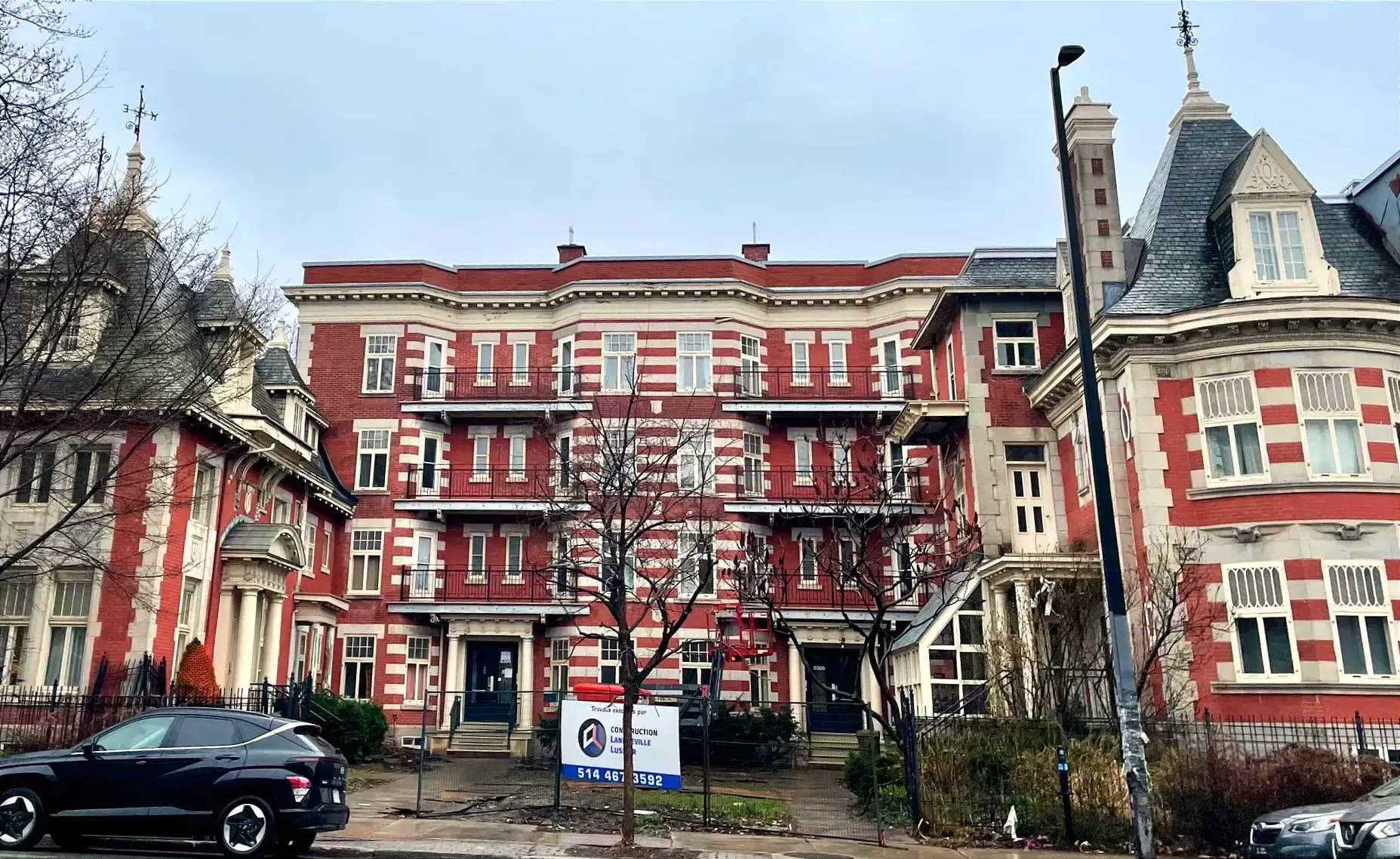 Vue de l'édifice à la palette corail et crème dont l'architecture est marquée de fioritures.