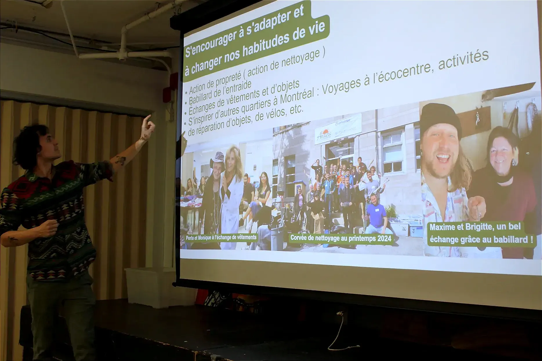 M. Allard pointe vert les projections de la présentation, qui se trouvent sur un écran derrière lui. 