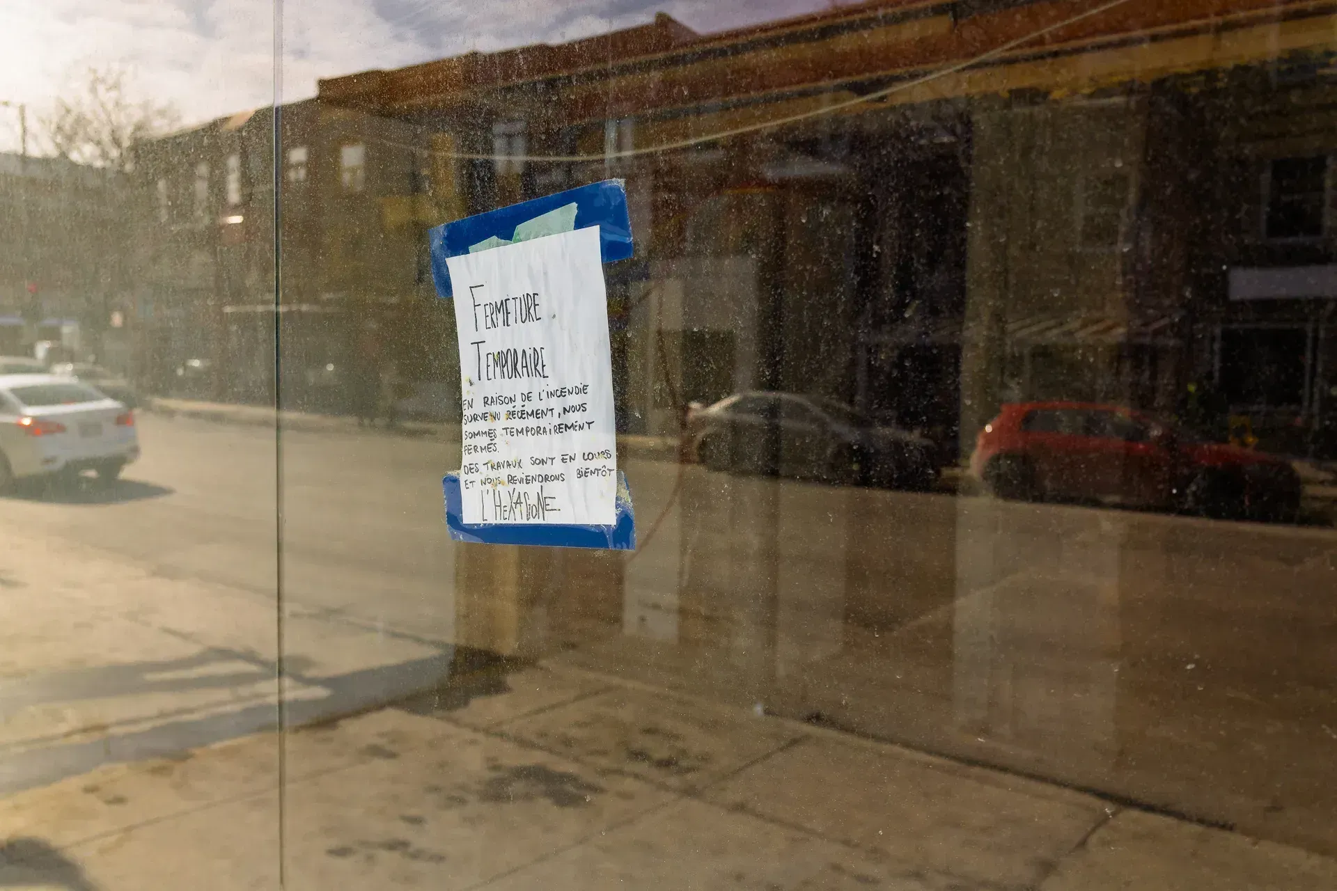Derrière le massage, à travers les réflexions de la vitre, on peut apercevoir le local vidé et en attente de rénovations.