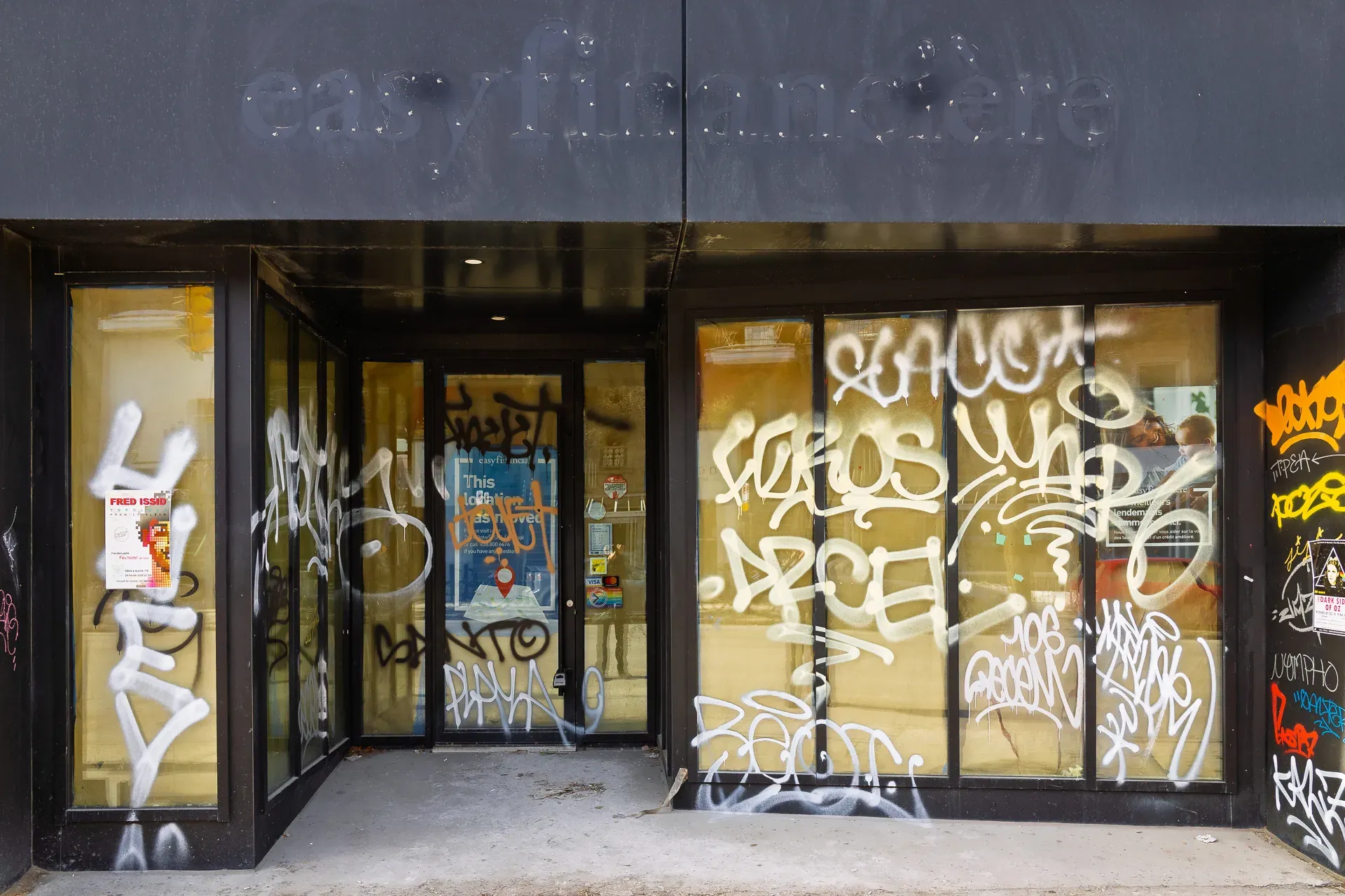 L'intérieur des vitres est recouvert de papier brun. Des graffitis en recouvrent l'extérieur. 