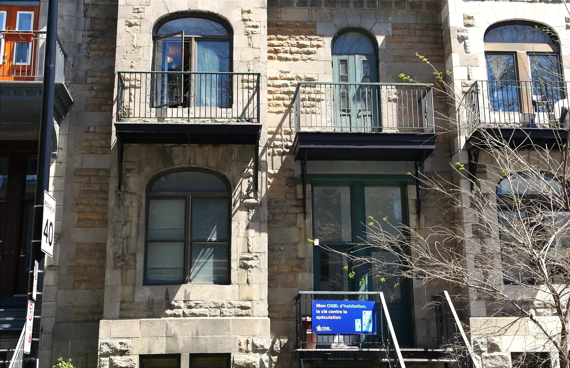 Façade d'un immeuble du quartier. On peut y voir une pancarte sur laquelle il est inscrit «Mon OSBL d'habitation, la clé contre la spéculation».