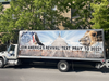 Sur le camion, on peut lire "Join America's revival! Text 'PRAY' to 20221" avec une image de la Maison Blanche, un aigle et un lion.