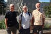 Les trois hommes posent devant la sculpture qui se trouve devant l'entrée du Centre du Plateau. 