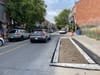 La rue Clark vers le nord avec, à droite, une fosse mince et longue remplie de terre à l'endroit où se stationnent habituellement des voitures.