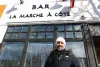Radi pose devant la façade de l'espace. On voit la bannière où est encore inscrit «BAR LA MARCHE À CÔTÉ»