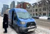 Une camionnette bleue est stationnée sur l'avenue du Parc, un jour d'hiver.