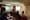 Une photo montre une dizaine de personnes assises dans une petite salle et qui écoutent une femme qui fait une présentation. 